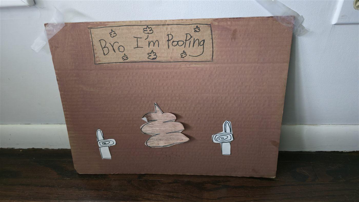 The original cardboard 'Bro I'm Pooping' sign Julianna made